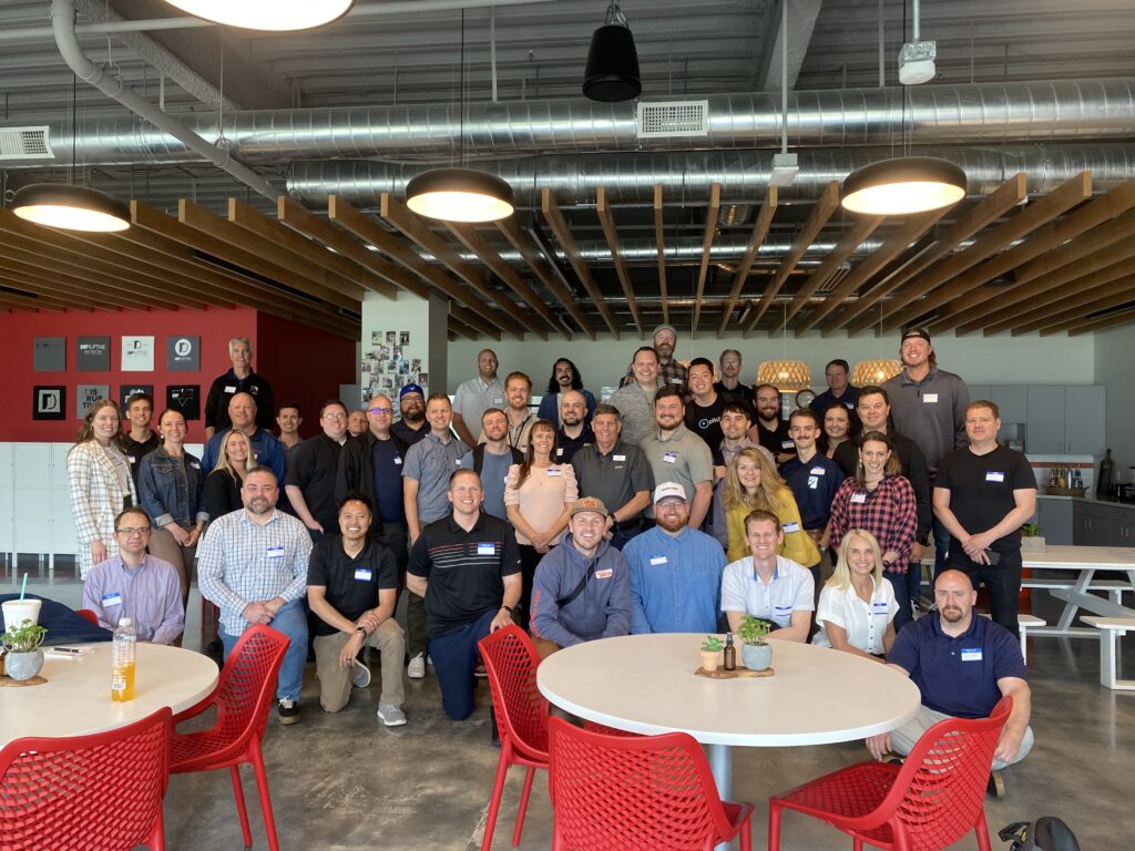 Group photo of about 50 men and women at the Utah Marketing Group meeting at Disruptive Advertising.