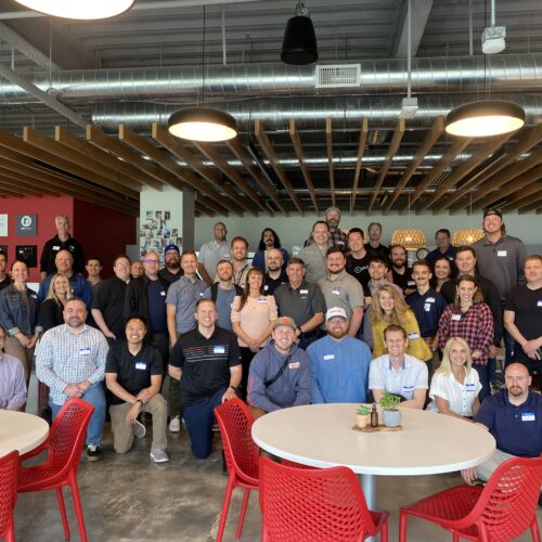 Group photo of about 50 men and women at the Utah Marketing Group meeting at Disruptive Advertising.