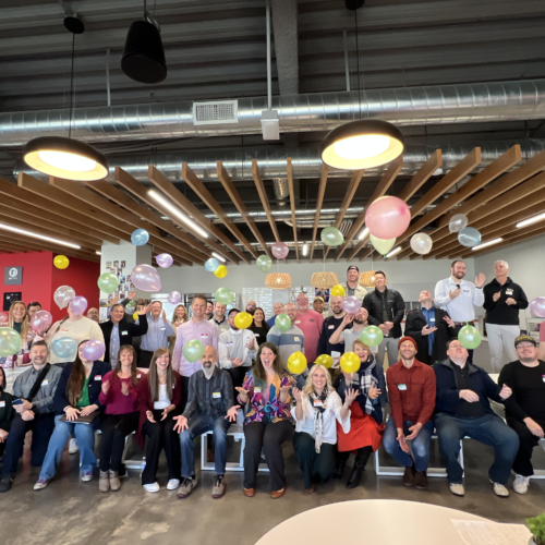 Group photo of Utah Marketing Group members tossing colorful balloons in the air.