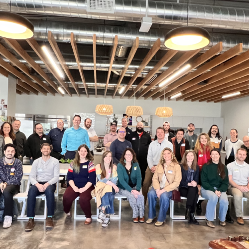 Group photo of Utah Marketing Group members sitting and standing in rows, smiling at the camera.