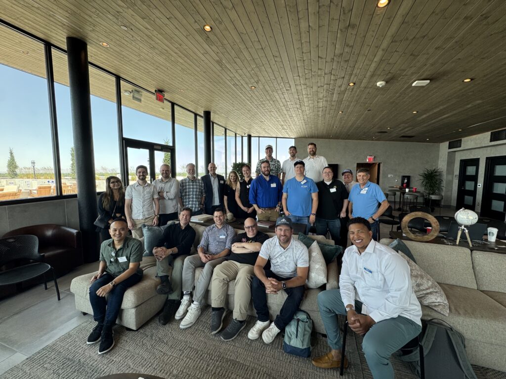 Members of the Utah Marketing Group standing and sitting in a large living area.