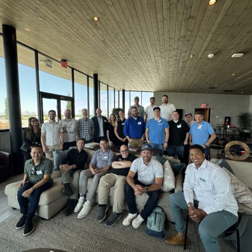 Members of the Utah Marketing Group standing and sitting in a large living area.