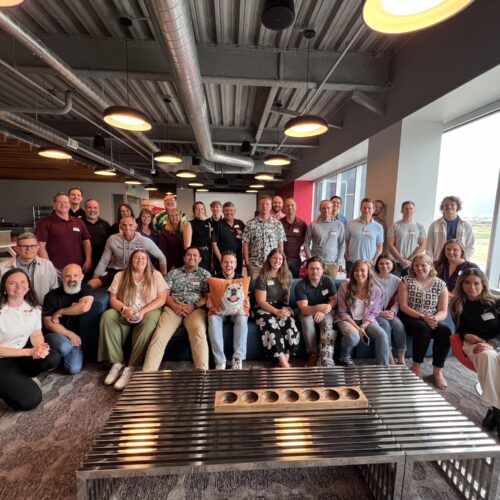 Members of the Utah Marketing Group standing and sitting in a large living area.