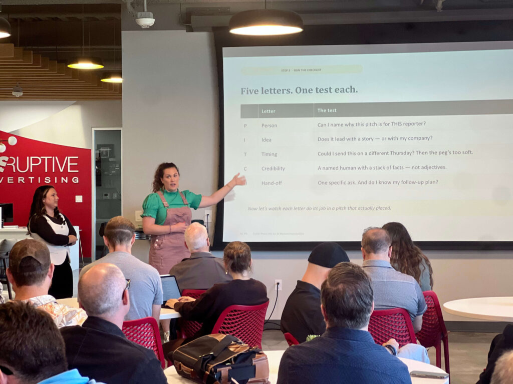 Utah Marketing Group attendees listen to a presentation on PR pitching, with a speaker explaining a five-part media pitch checklist.